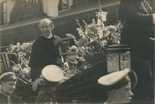 860655 Afbeelding van pastoor Sebastianus van Nuenen (1898-1966), staande in een open koets in de feestelijke optocht ...
